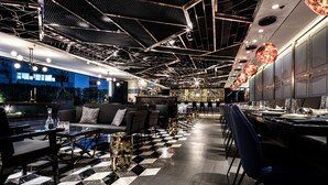A modern bar area with a checkered floor, bar stools, and a pool table. - Hotel COZi · Oasis (Kwai Chung)