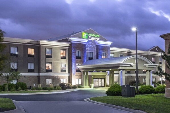 A Holiday Inn Express hotel with a covered entrance, brick facade, and a well-lit sign.