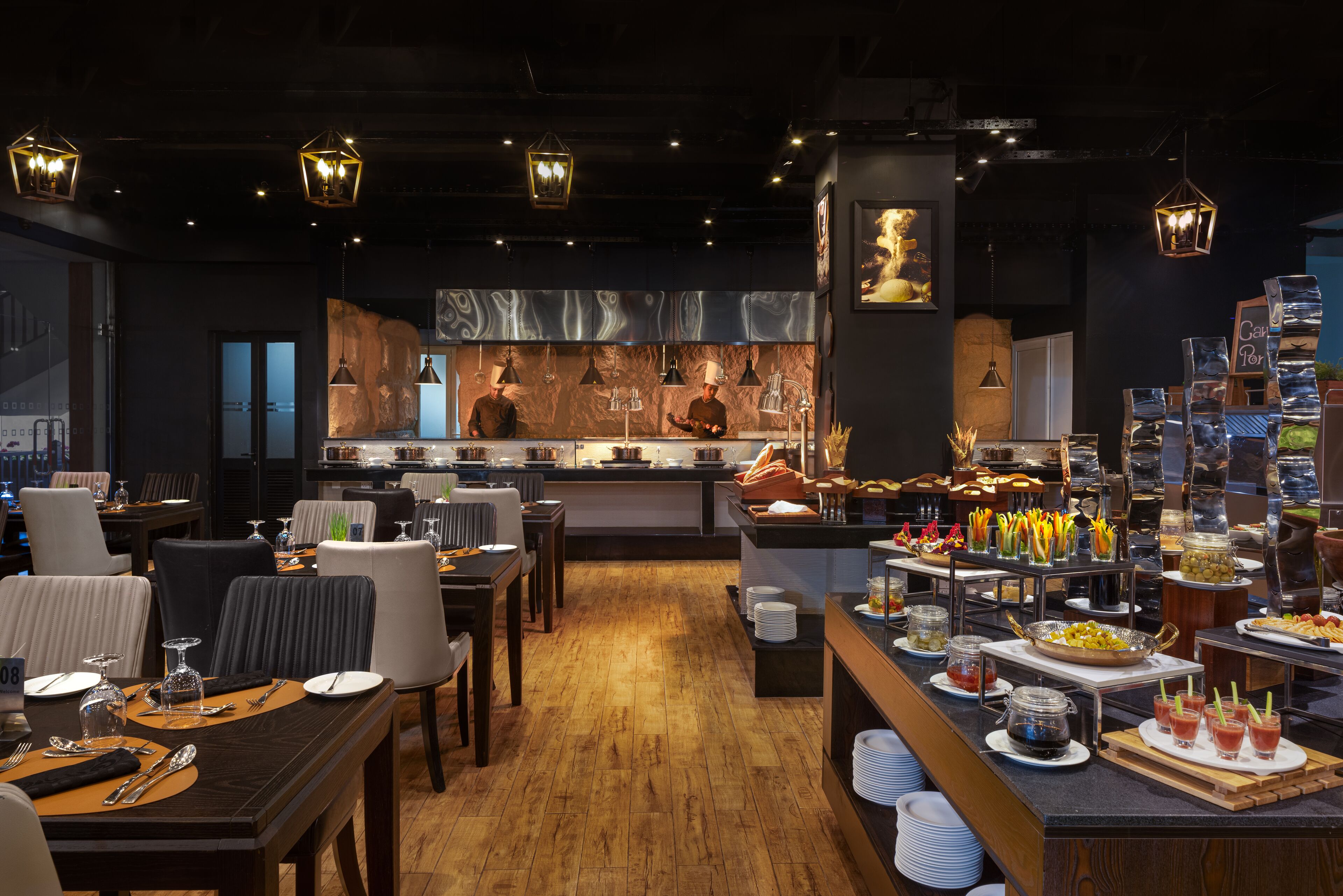 A restaurant with a modern interior, wooden flooring, and a buffet area with various food items and drinks.