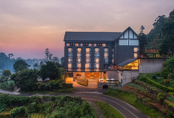 A modern hotel with a prominent entrance, multiple floors, and a landscaped garden area. - The Golden Ridge Hotel (Nuwara Eliya)