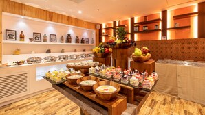 A buffet area with various food items and a fruit display. - Divine Clarks Inn Suites (Thanesar)