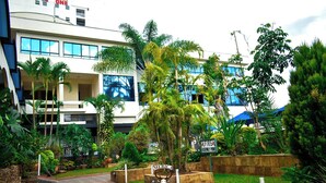 A hotel entrance with a sign indicating a fire assembly point and a motorcycle.