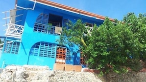 A two-story building with a blue facade, multiple windows, and a red roof. - Anthonys Beach Resort (Moalboal)