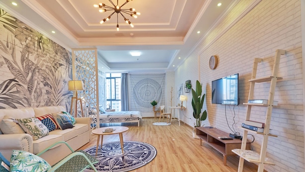 Una sala de estar moderna con un sofá, una mesa de centro y un televisor montado en la pared.