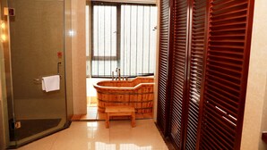 Une salle de bain moderne avec une douche à parois de verre, une baignoire en bois et un banc.