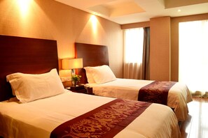 A hotel room with two beds, a nightstand with a lamp, and a window with curtains. - Nan He Xi Yue Hotel (Chengdu)