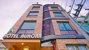 A hotel named "Hotel Aurora" with a modern architectural design featuring brickwork and large windows. - Hotel Aurora (Mandalay)