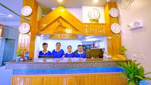 A reception desk with clocks displaying times for Paris, Berlin, Bangkok, and Beijing. - Hotel Aurora (Mandalay)