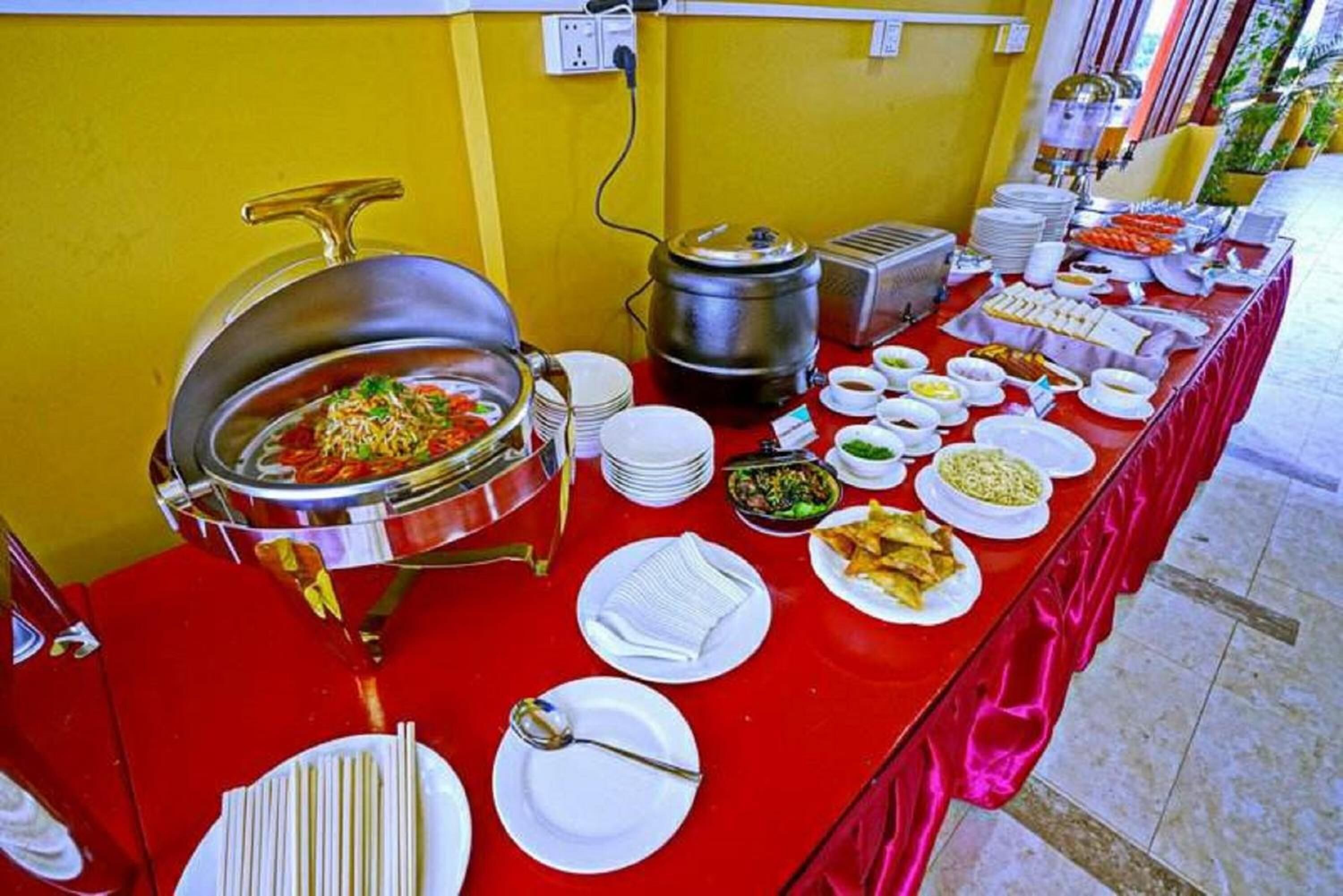 A buffet table with various dishes and a hot pot.