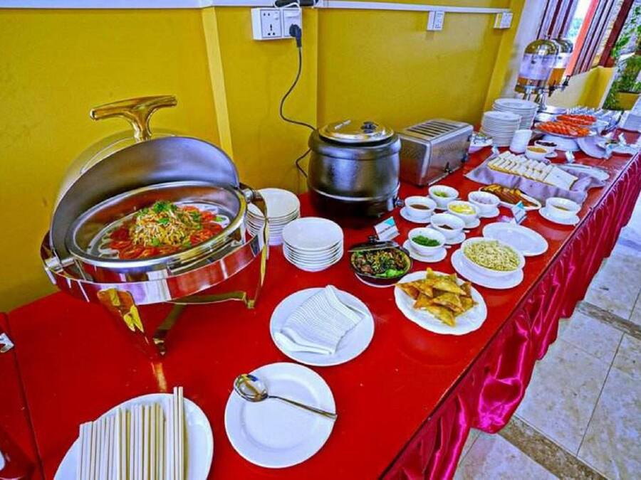 A buffet table with various dishes and a hot pot.