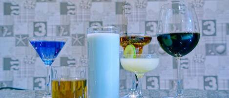 Variedad de bebidas en distintos vasos sobre una barra.