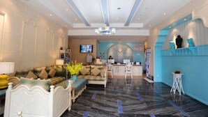 A hotel lobby with a reception desk, seating area, and a television. - Chengdu Charm City Hotel (Chengdu)