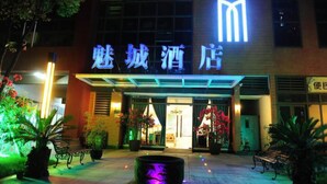 A hotel entrance with illuminated signage and potted plants. - Chengdu Charm City Hotel (Chengdu)