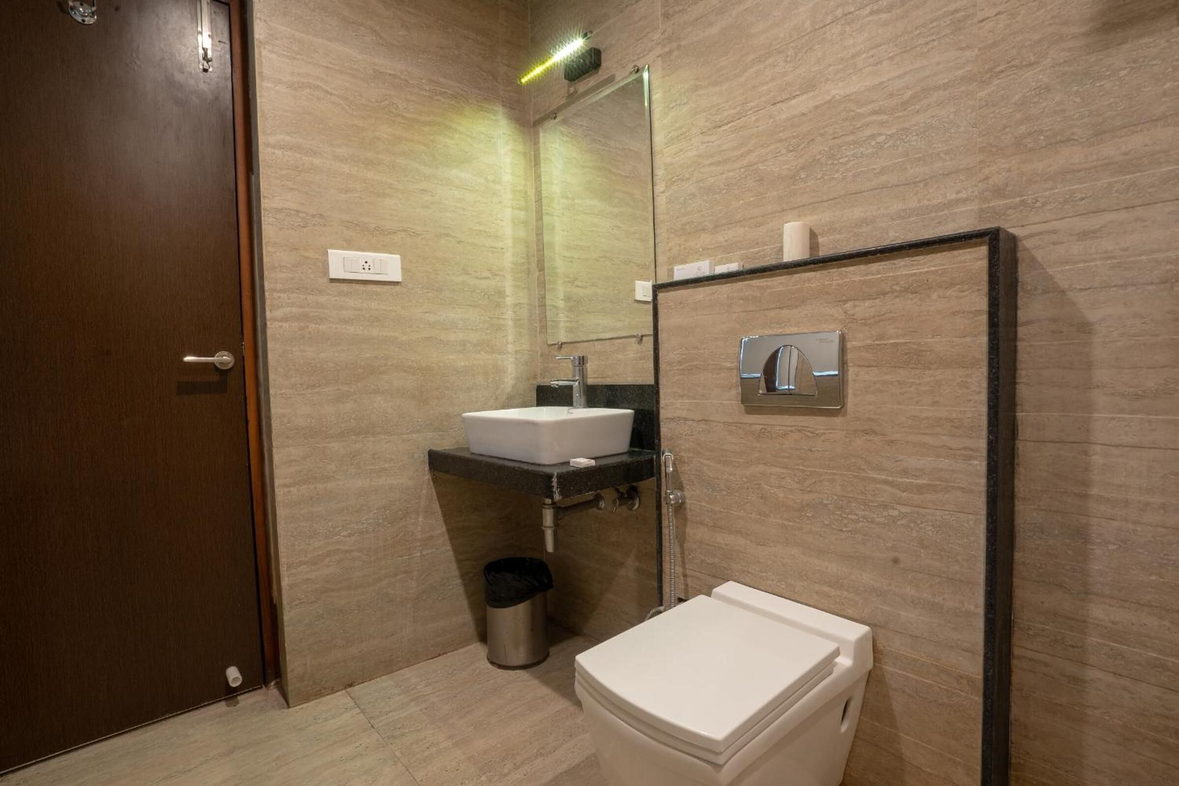 A modern bathroom with a toilet, sink, and mirror.