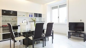 A modern kitchen with a dining area, a TV, and a window. - Flaminio & Popolo Large Apartment (Rome)