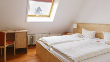 Ein Schlafzimmer mit zwei Betten, einem Schreibtisch und einem Stuhl.
