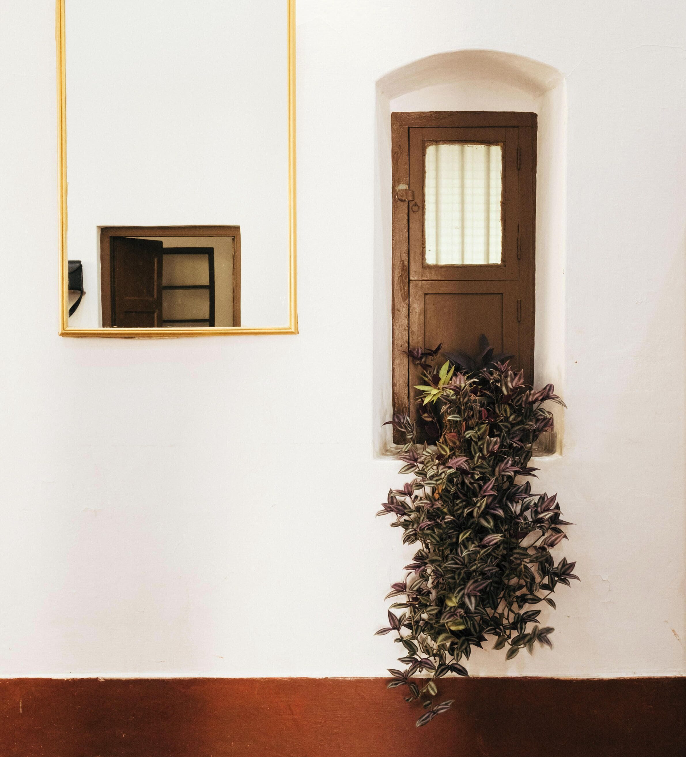 A white wall with a wooden door and a small window.