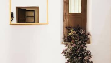 A white wall with a wooden door and a small window.