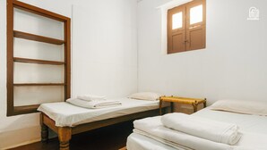 A room with two wooden beds, a wooden wardrobe, and a small window with two panes. - Laika Heritage Stay by evaddo stays (Mysore)