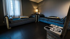 A modern living room with dark flooring, a sofa, a coffee table, and a lamp. - Il Covo (Rome)