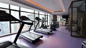 A gym with treadmills, exercise bikes, and a reception desk. - Mercure Chengdu Chunxi Taikoo Li (Chengdu)