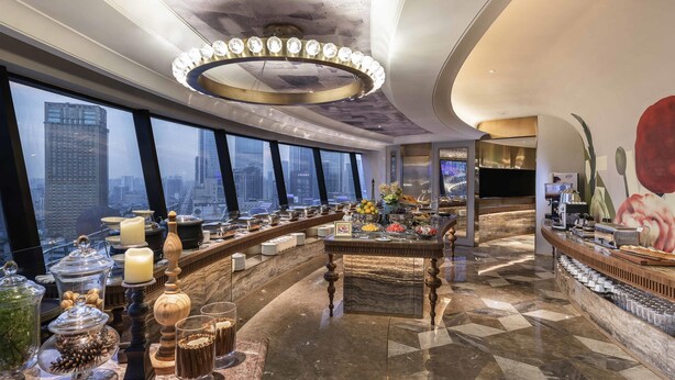 A high-rise hotel lobby with a long buffet table, a large chandelier, and a city view. - Mercure Chengdu Chunxi Taikoo Li (Chengdu)