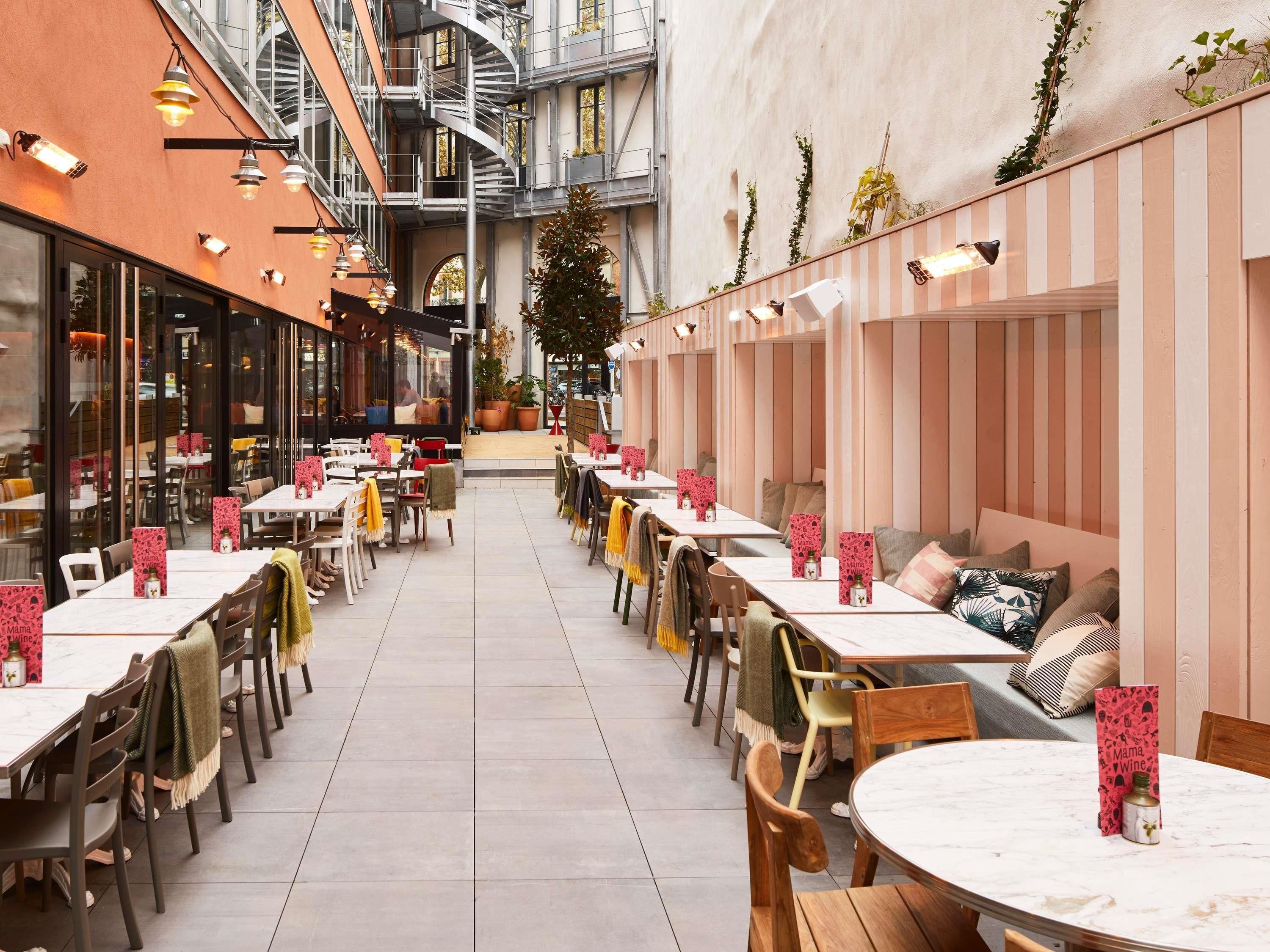 A restaurant with outdoor seating, a spiral staircase, and a view of the street.