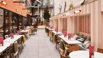A restaurant with outdoor seating, a spiral staircase, and a view of the street.