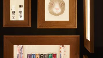 A wall with framed artwork and shelves displaying various products.