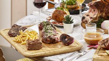 A dining table with various dishes including steak, fries, and a salad.