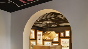 Un intérieur moderne avec un comptoir en bois et des œuvres d’art encadrées accrochées aux murs.