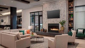 A modern living room with a fireplace, sofas, armchairs, and a bookshelf. - Residence Inn by Marriott Bend (Bend)