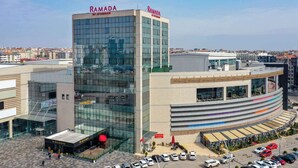 Un edificio moderno con el nombre 'RAMADA' bien visible en la fachada.