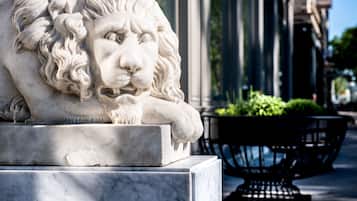 Una estatua de león de mármol sobre un pedestal.