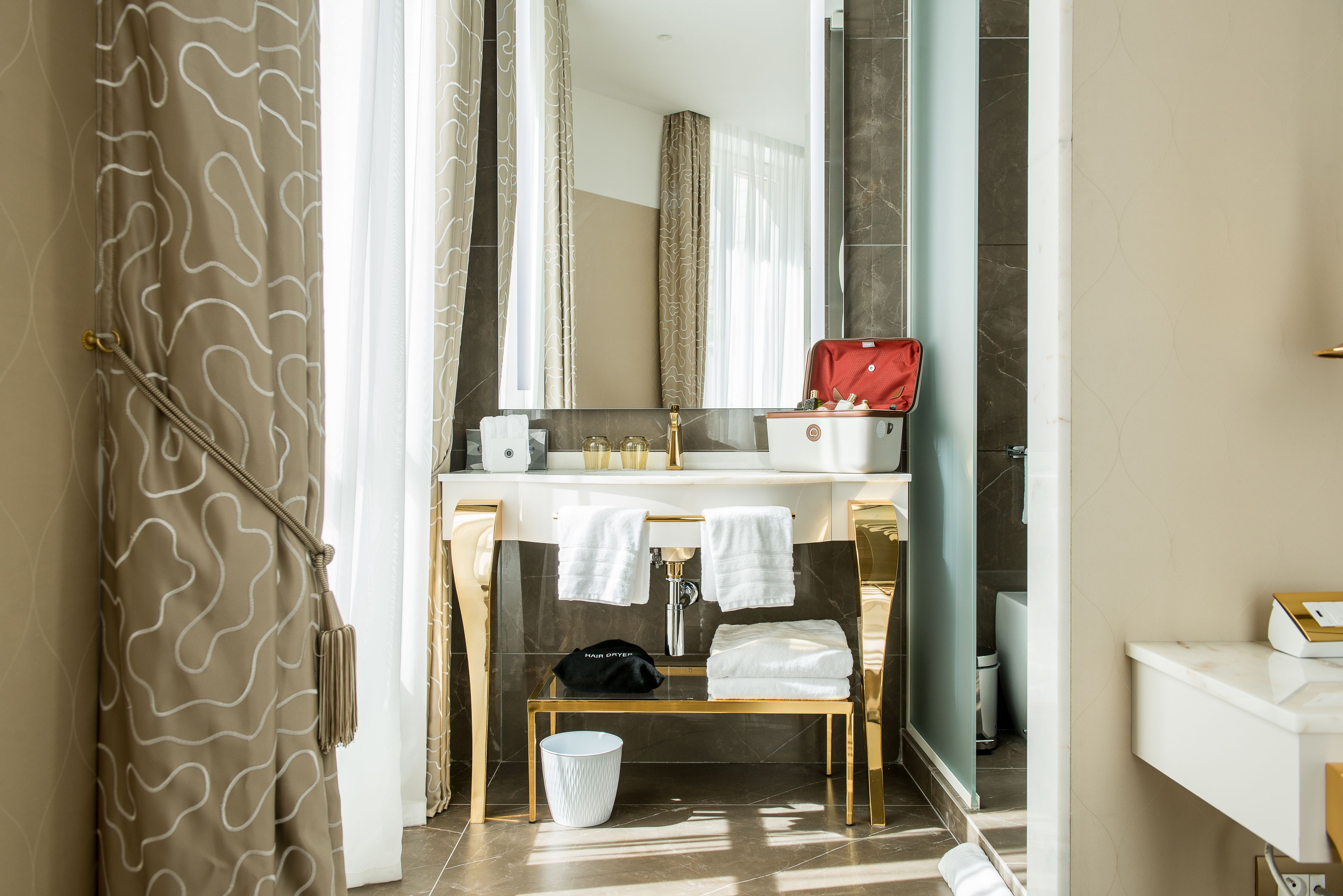 A bathroom with a vanity, a mirror, a sink, and a shower area.