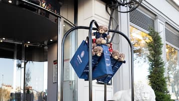 A glass display case with blue bags and a teddy bear.