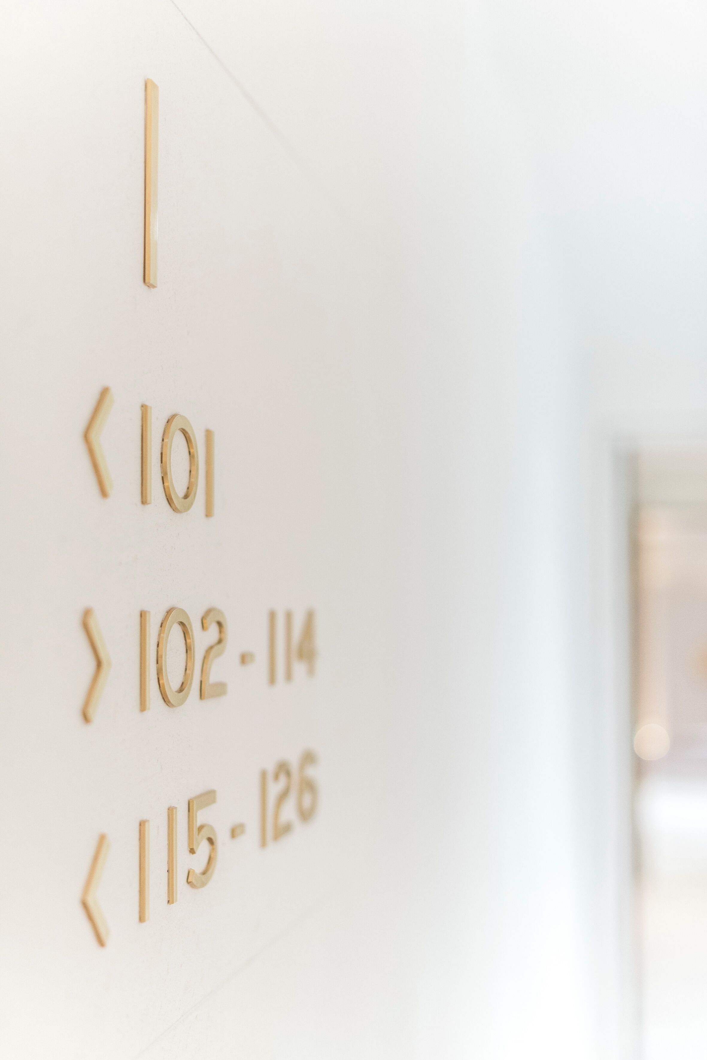 Eine Wand mit Pfeilen und Zimmernummern, die Zimmerzuordnungen in einem Hotel zeigen.