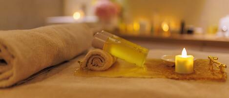 A towel, a bottle, and a candle on a table.