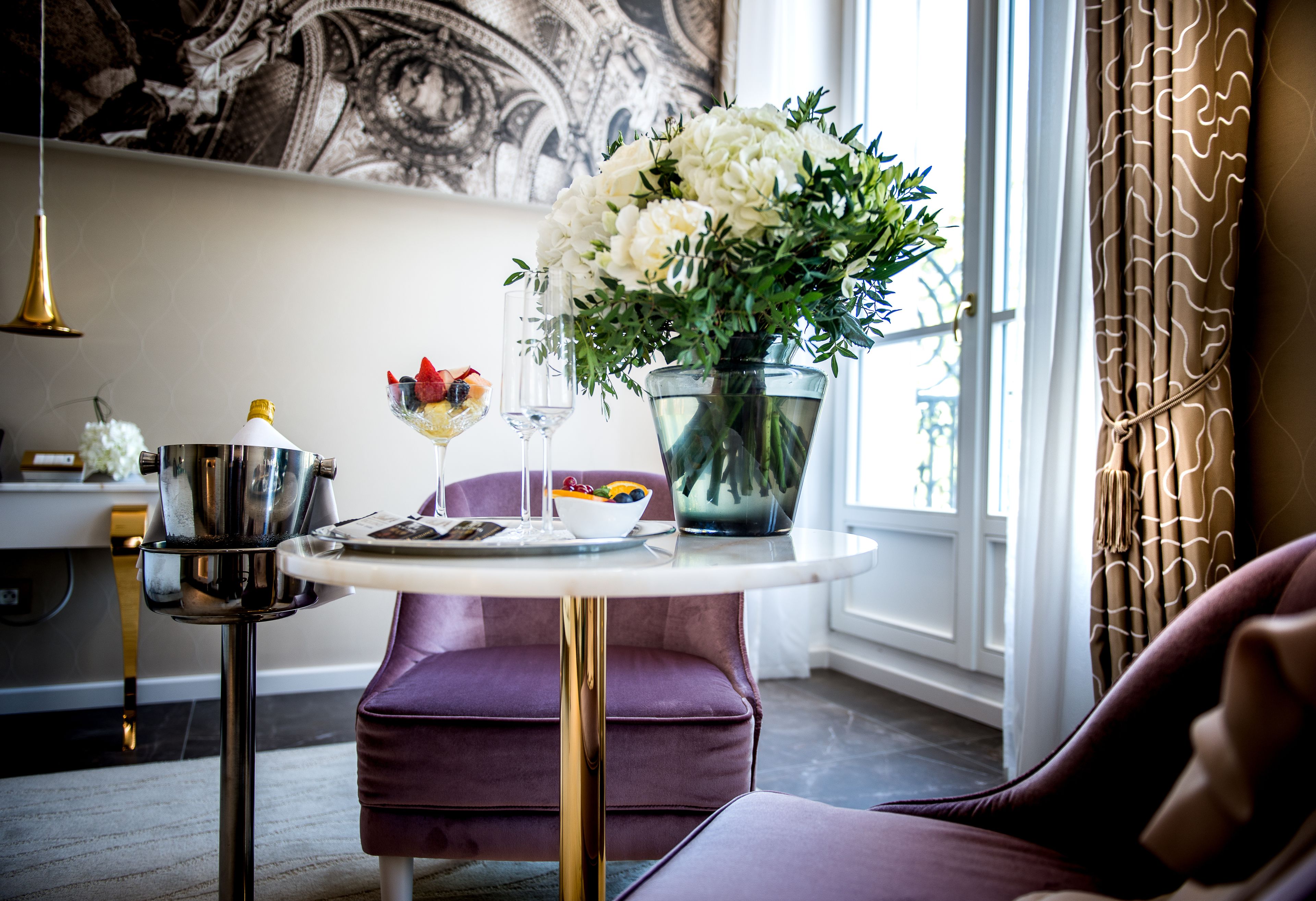 Un coin repas avec une table, une chaise violette et un vase rempli de fleurs.