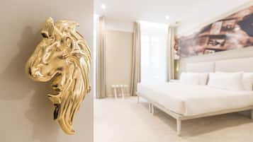 Una camera d'albergo moderna con un letto grande, un divano bianco, un tavolino e una decorazione a testa di cavallo dorata a parete.