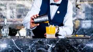 Un camarero sirviendo una bebida en un vaso.