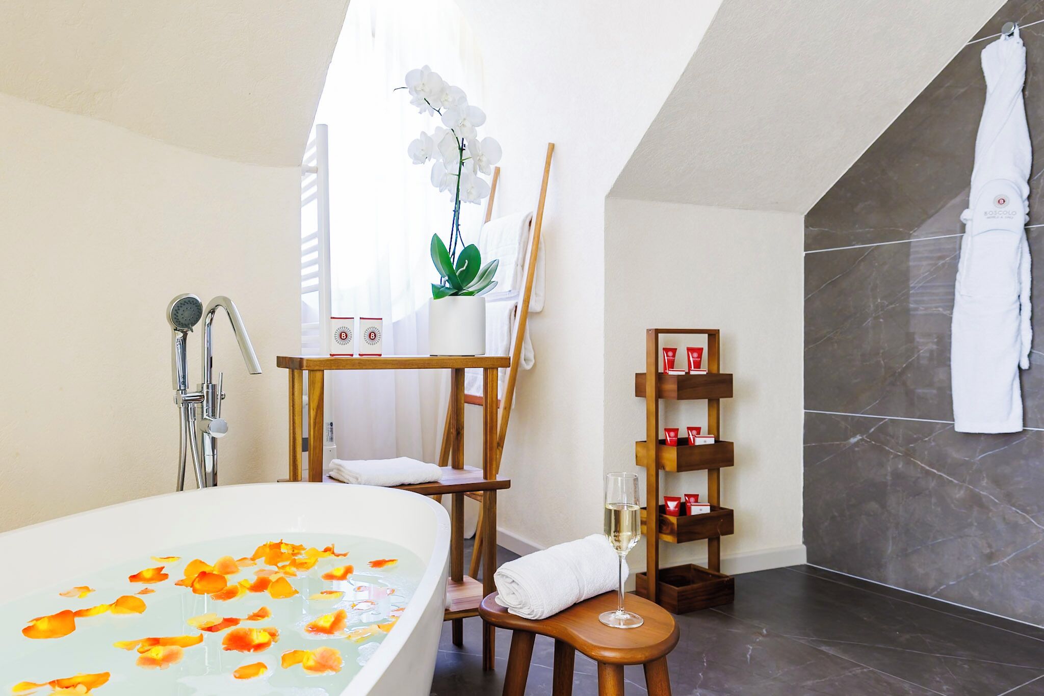 Un bagno moderno con vasca, doccia e una sedia di legno.