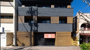 A modern building with a dark facade, multiple balconies, and a wooden entrance. - Stay SAKURA Kyoto Gyoen East (Kyoto)