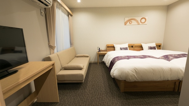 A hotel room with a bed, a TV, a sofa, and a desk. - Stay SAKURA Kyoto Gyoen East (Kyoto)