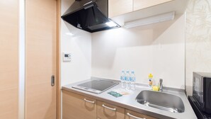 A compact kitchen with a microwave, sink, and a small countertop. - Stay SAKURA Kyoto Gyoen East (Kyoto)