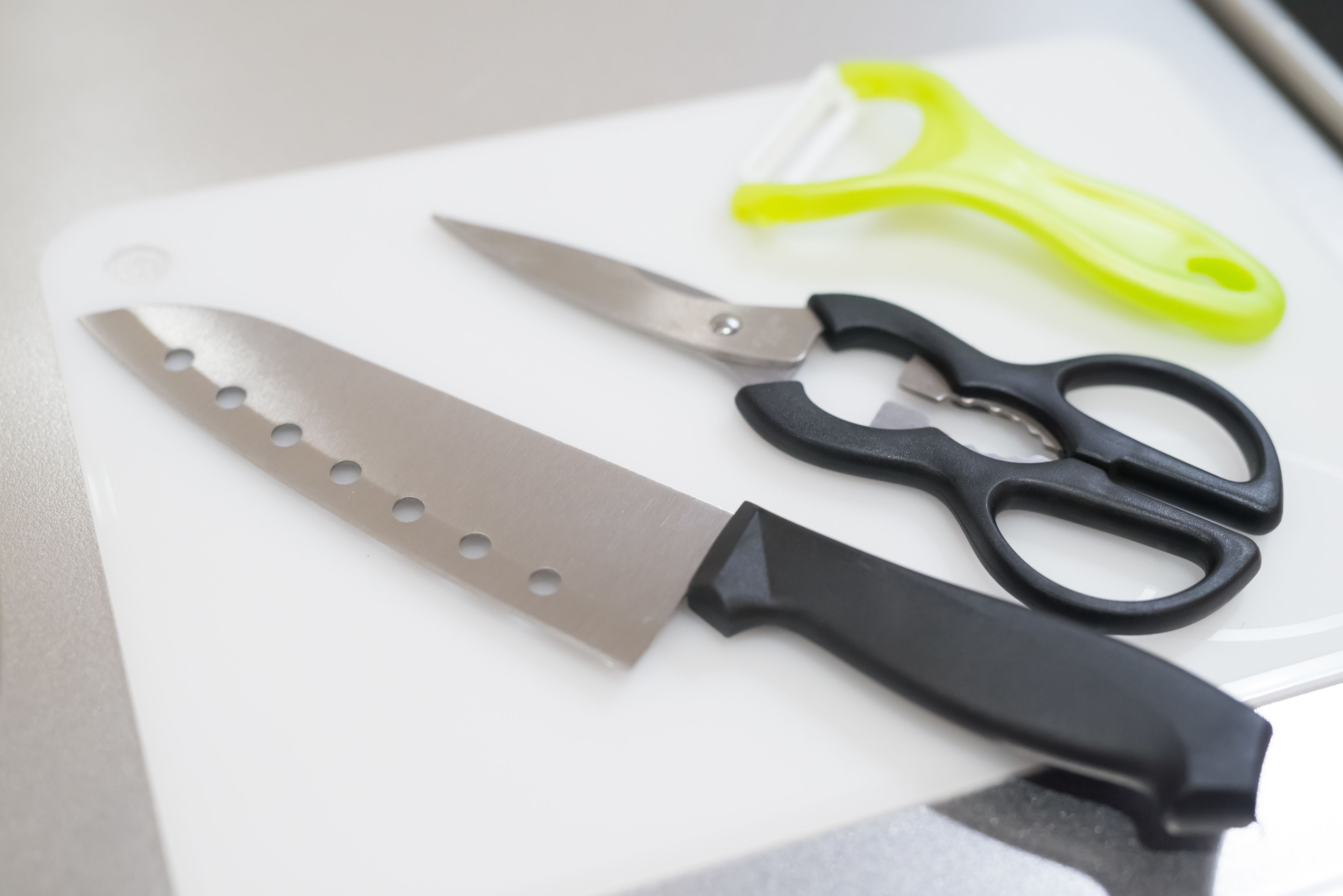 A kitchen counter with a knife and scissors.