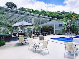 Una piscina al aire libre, sillones reclinables de piscina