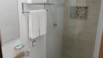 A modern bathroom with a glass-enclosed shower, a white sink, and a toilet.