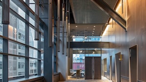 A modern interior with a high ceiling, large windows, and a central elevator area. - Hyatt Regency Seattle (Seattle)