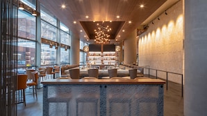 A modern restaurant interior with a bar area, seating, and a view through large windows. - Hyatt Regency Seattle (Seattle)